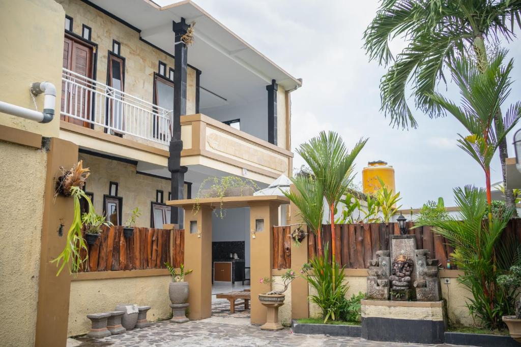 una casa con una recinzione in legno e palme di Twin OLA a Tabanan