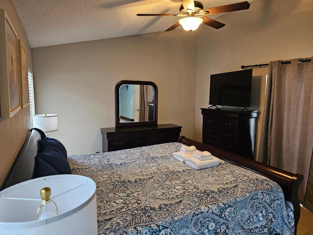 a bedroom with a bed and a mirror and a tv at Minnie Heaven in Kissimmee