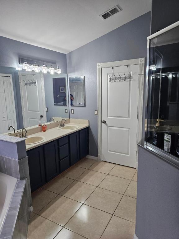 a bathroom with two sinks and a large mirror at Minnie Heaven in Kissimmee