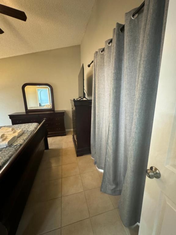 a bathroom with curtains and a vanity and a mirror at Minnie Heaven in Kissimmee