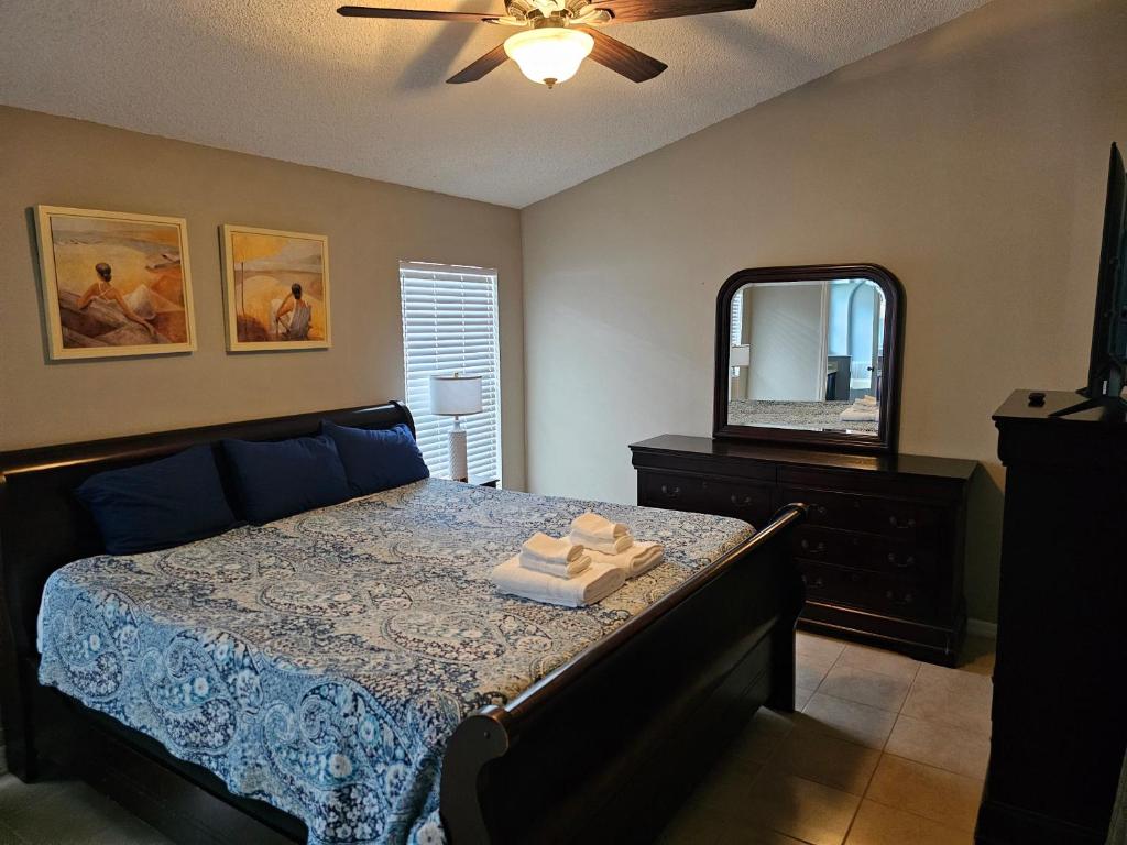 a bedroom with a bed with a dresser and a mirror at Minnie Heaven in Kissimmee
