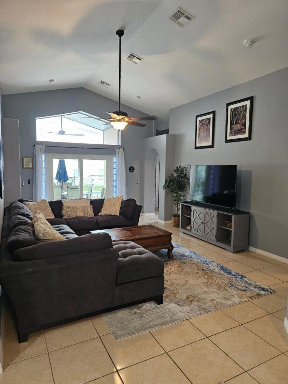 a living room with a couch and a flat screen tv at Minnie Heaven in Kissimmee