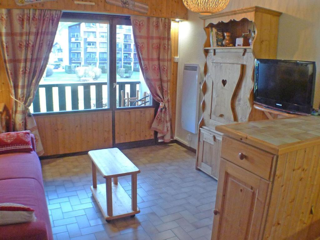 une cuisine avec un canapé, une télévision et une fenêtre dans l'établissement Studio cabine, balcon, internet et animaux admis - FR-1-629-136, à Samoëns
