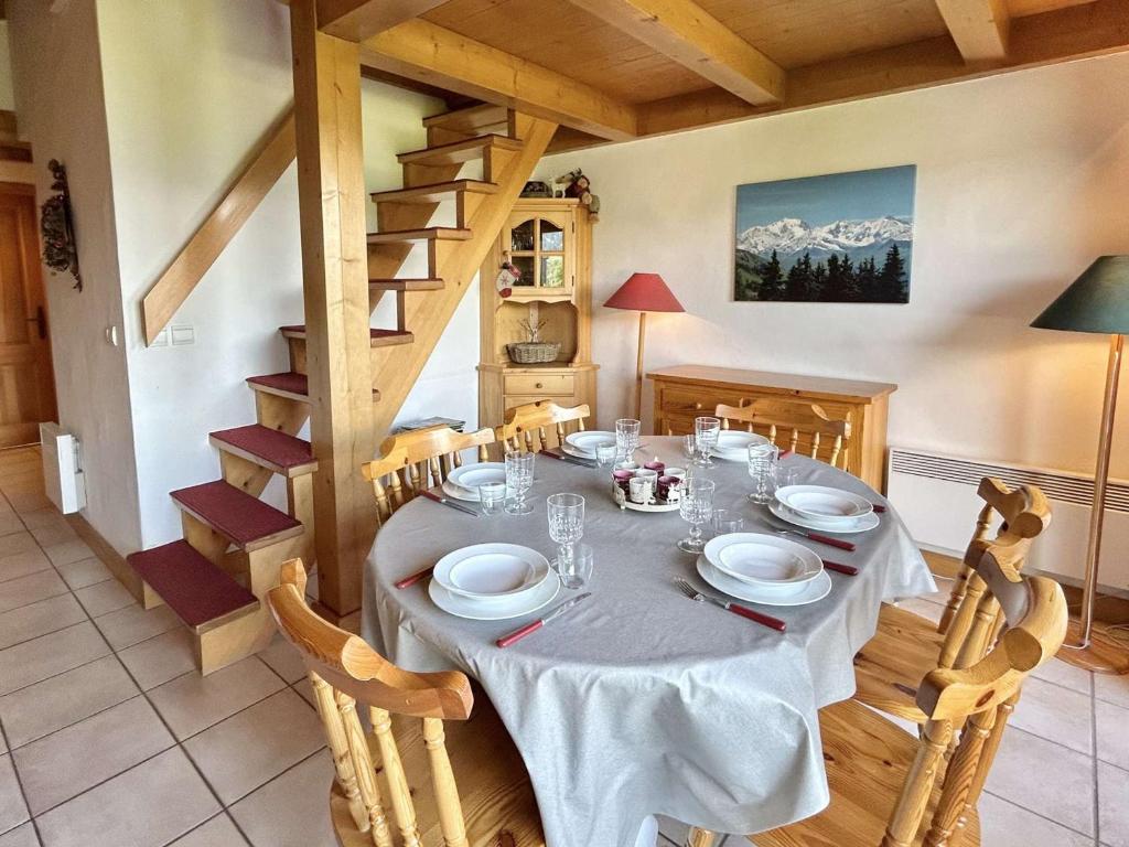 une salle à manger avec une table et des chaises et un escalier dans l'établissement Appartement 3 Pièces + Mezzanine, 7 couchages, 2 Balcons, Parking - FR-1-597-177, à Combloux
