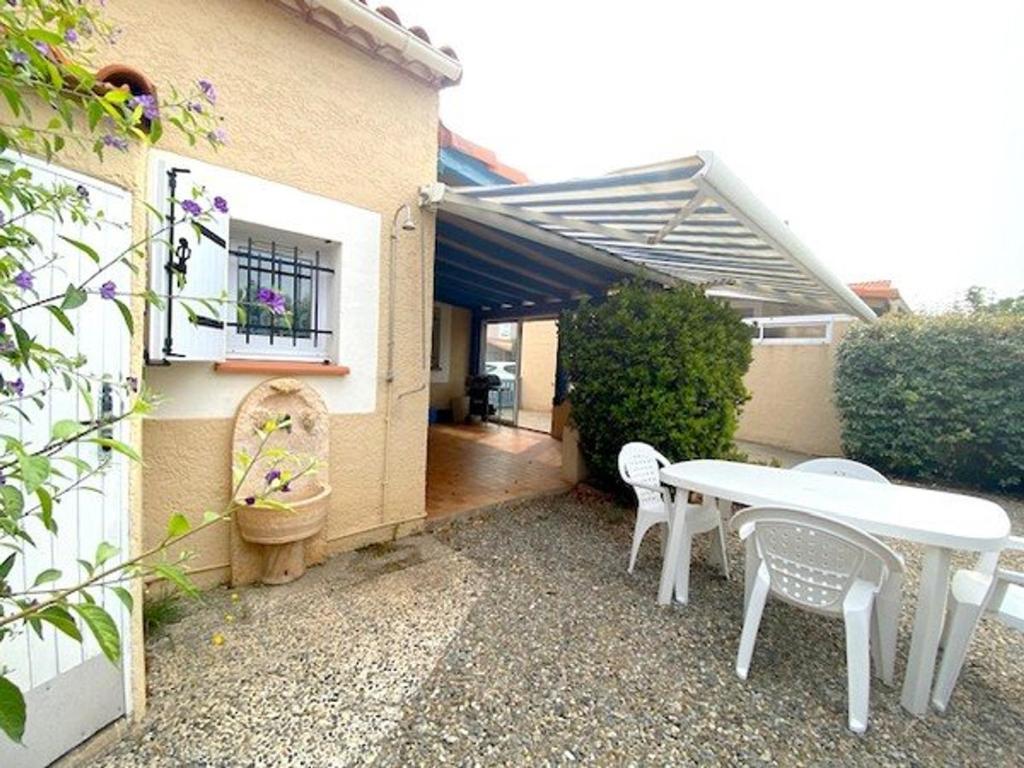 une table et des chaises blanches à l'extérieur d'une maison dans l'établissement Villa familiale proche plage avec jardin et terrasse, 6 personnes, WIFI, parking inclus - FR-1-782-67, au Barcarès