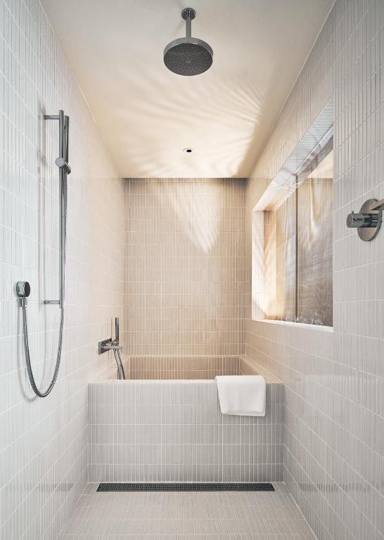 a white bathroom with a tub and a shower at Kimpton Da An Taipei- an IHG Hotel in Taipei