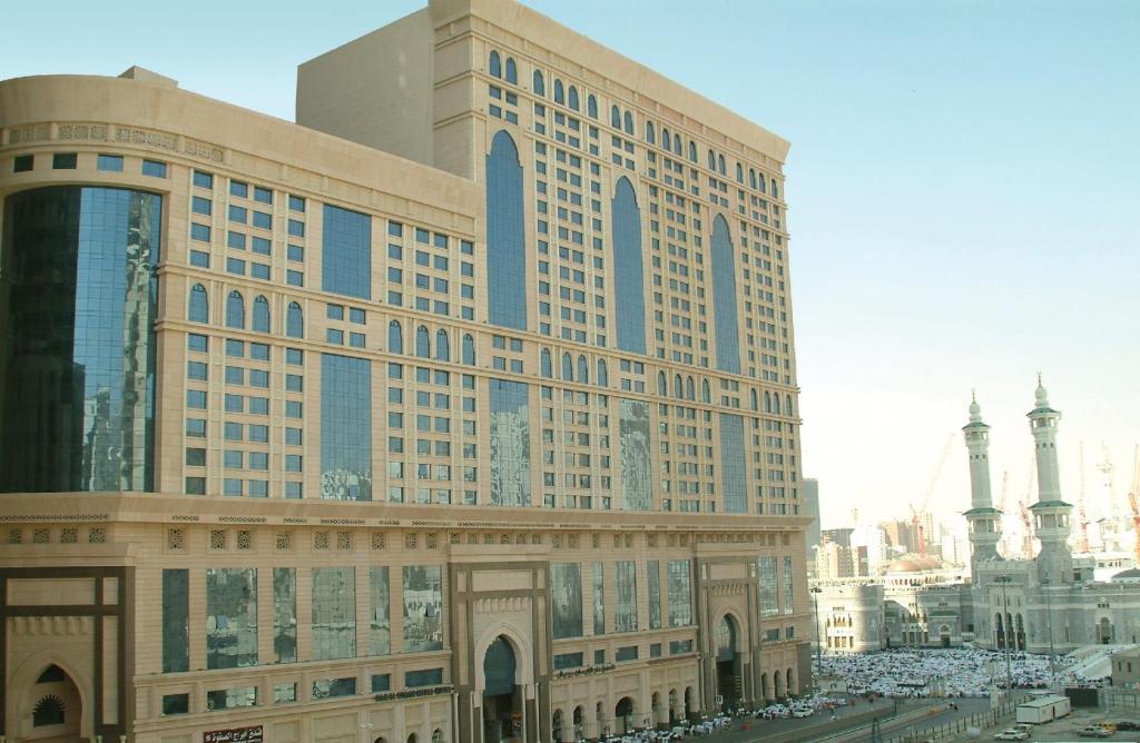 麥加的住宿－Dorrar Al Eiman Royal Hotel，一座大型建筑,前面有汽车停放