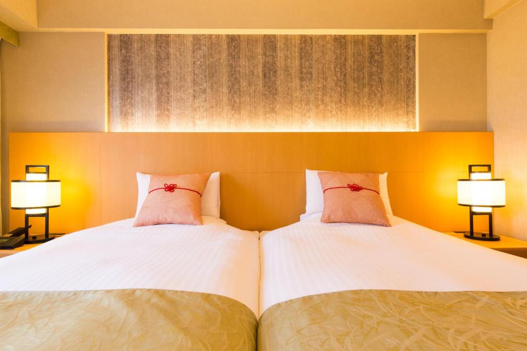 two beds sitting next to each other in a bedroom at Kyoto Brighton Hotel in Kyoto
