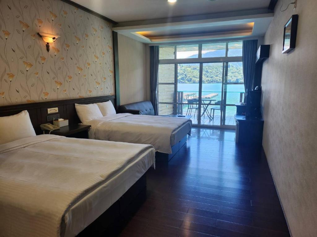 a hotel room with two beds and a balcony at Sun Fog Hotel in Yuchi