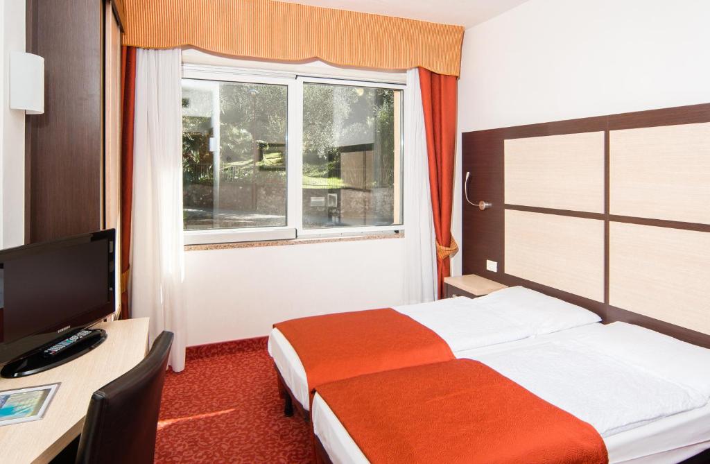 Postel nebo postele na pokoji v ubytování Hotel Benacus Panoramic
