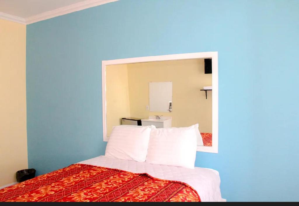 Un dormitorio con una cama con un espejo grande. en Plaza Hotel Gardena, en Gardena