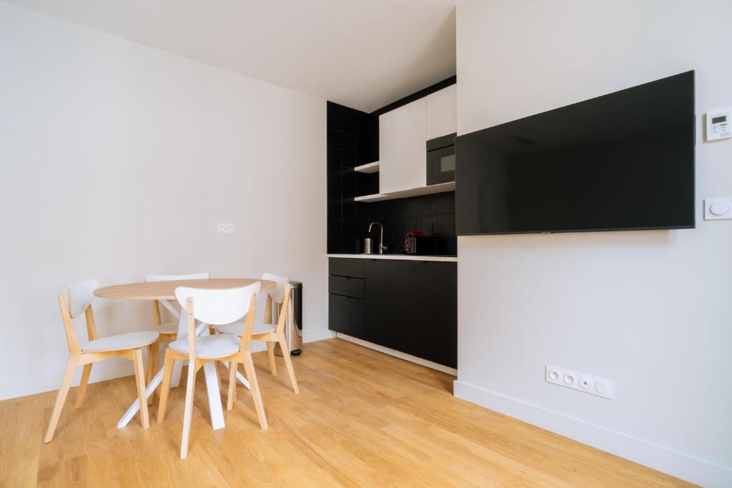 une cuisine et une salle à manger avec une table et des chaises dans l'établissement Welcoming 1 Bedroom Apartment in Paris, à Paris