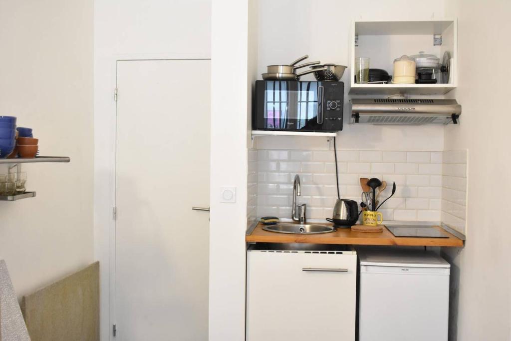 une cuisine avec des armoires blanches et un évier dans l'établissement Functional Studio In Paris, à Paris