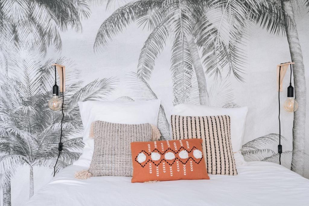 - une chambre avec un lit avec deux oreillers et des palmiers dans l'établissement Alluring 1 bedroom Apartment 5 min to the Eiffel Tower!, à Paris