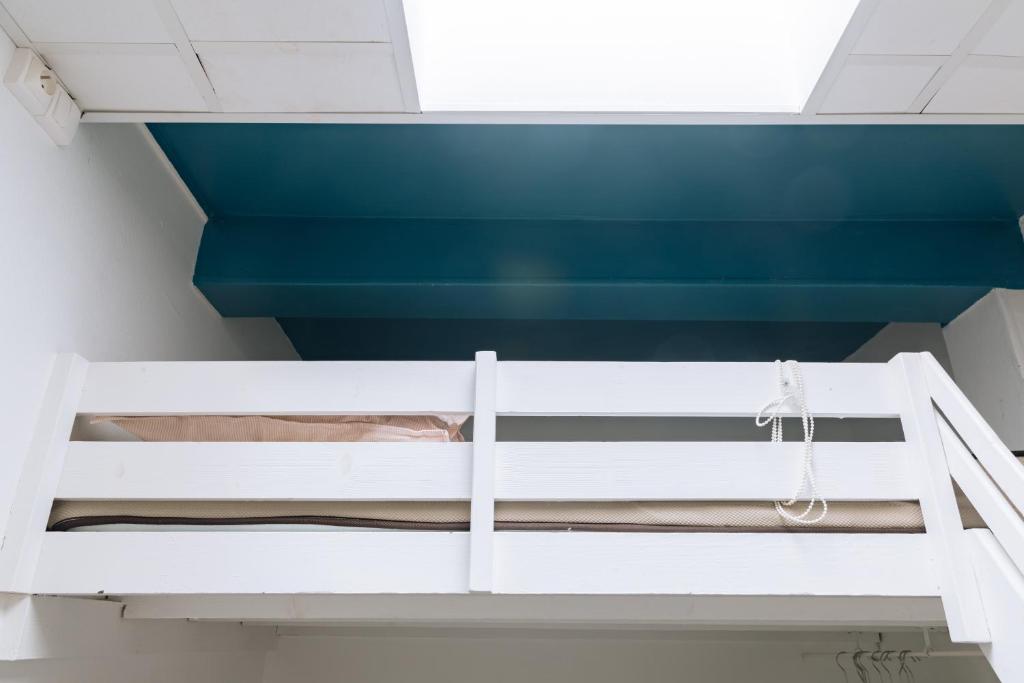 Ce lit superposé blanc se trouve dans un dortoir. dans l'établissement Chic Studio Apartment for 3 - La Villette!, à Paris