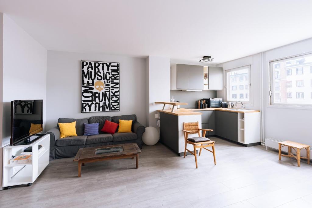 un salon avec un canapé et une cuisine dans l'établissement Exuberant 1BD Apartment near Canal Saint-Martin!, à Paris