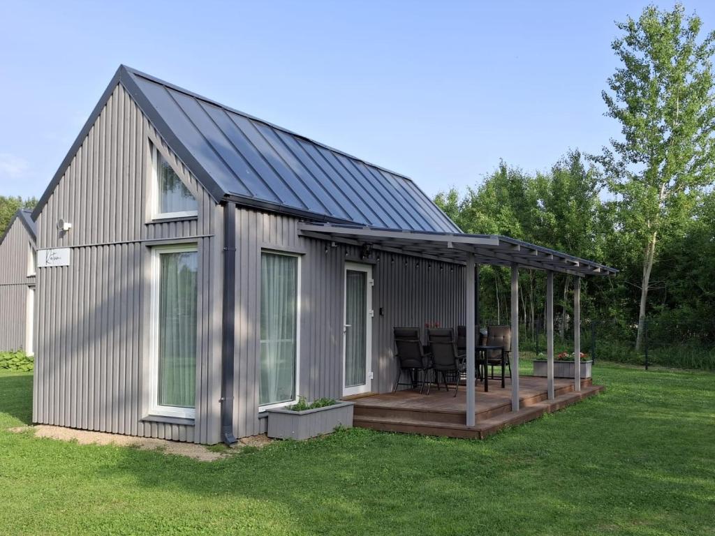 a metal building with a deck and a house at Rietumi in Kolka