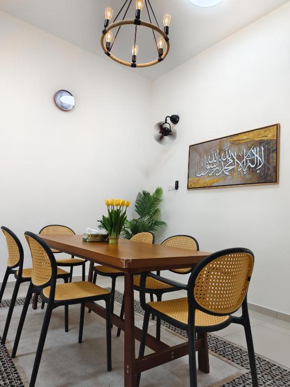 a dining room with a wooden table and chairs at Sakeenah Homestay near UUM, UNIMAP and Matrik Kedah in Changlun