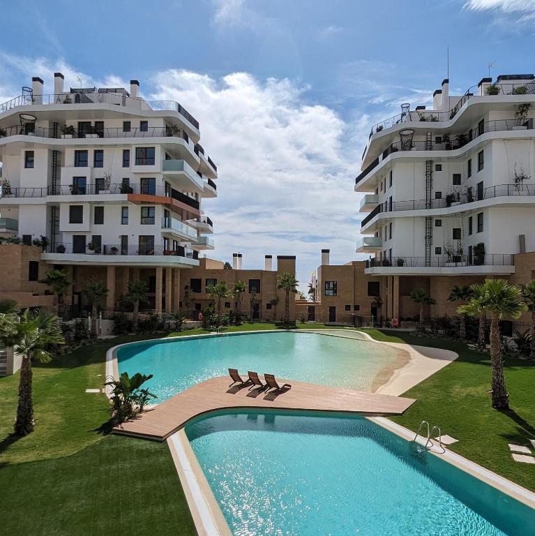 a swimming pool in front of two tall buildings at ASTER magic dúplex in Villajoyosa