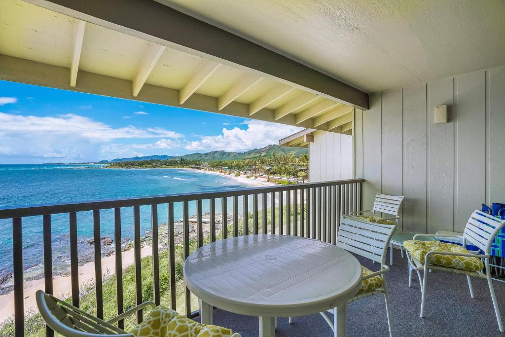 卡帕阿Charming Wailua Bay View Oceanfront Top Floor with an Amazing View!的带桌椅和海景的阳台