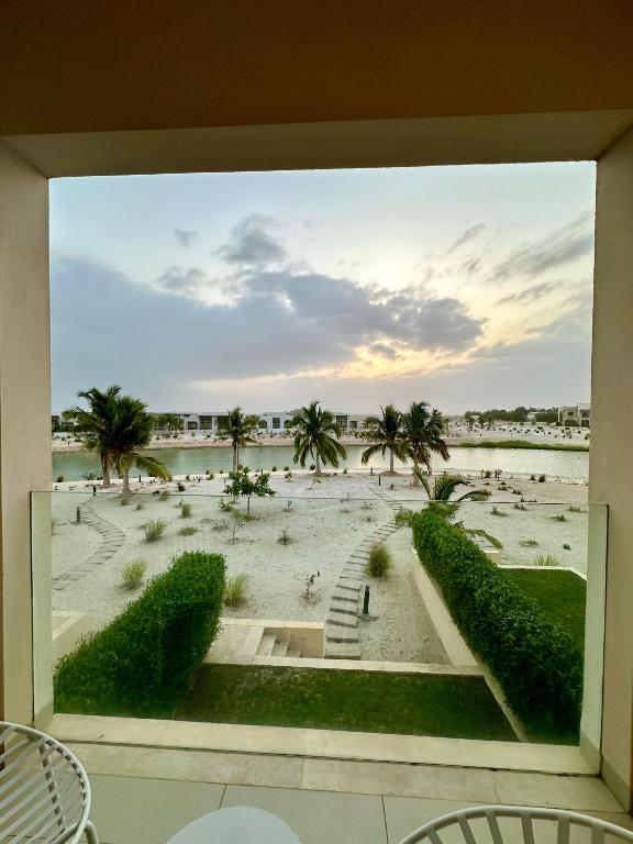 a view of the beach from a balcony of a resort at 2 Hawana VIP Studio in Ma‘mūrah