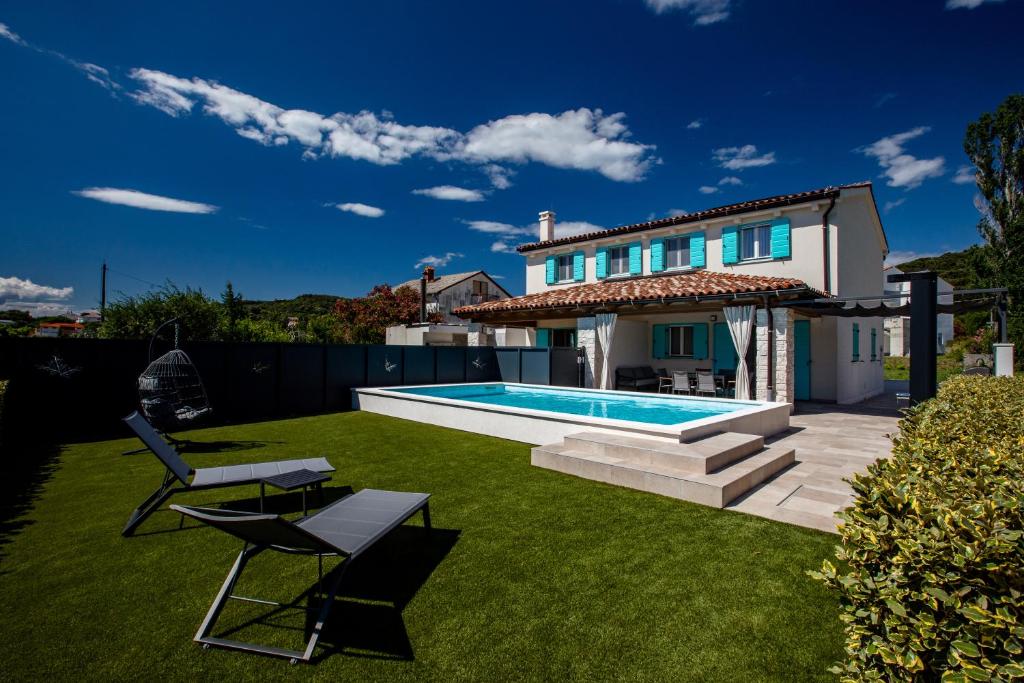 a backyard with a swimming pool and a house at Apartma Stara Maslina in Rab