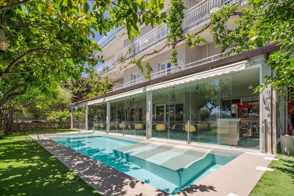 an exterior view of a building with a swimming pool at Hotel Rivage Taormina in Taormina