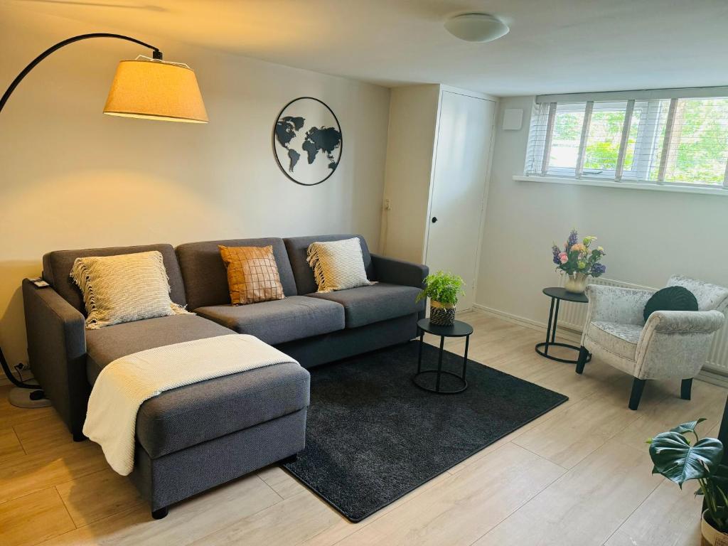 a living room with a couch and a chair at Souterrain Boslaan Katwijk aan zee in Katwijk aan Zee