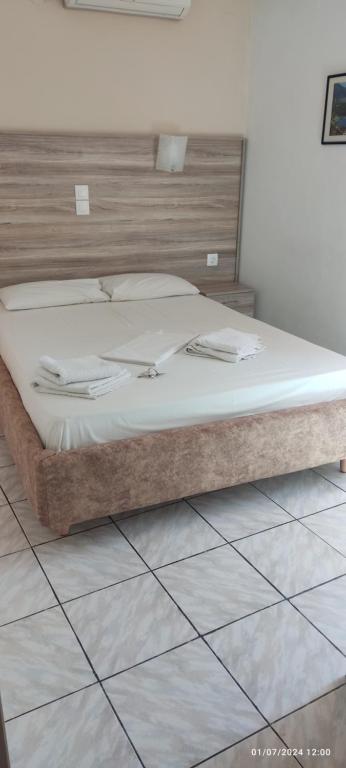 a bed in a bedroom with a wooden headboard at Homer's Studio in Nydri