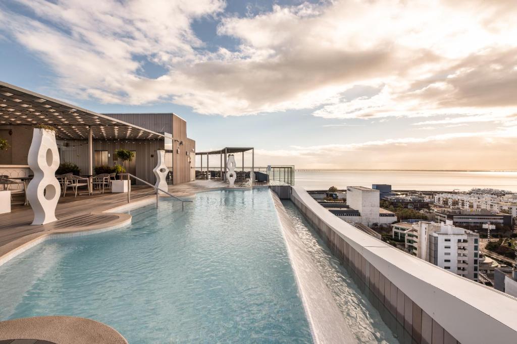 A rooftop pool facing a broad coastal and city panorama.