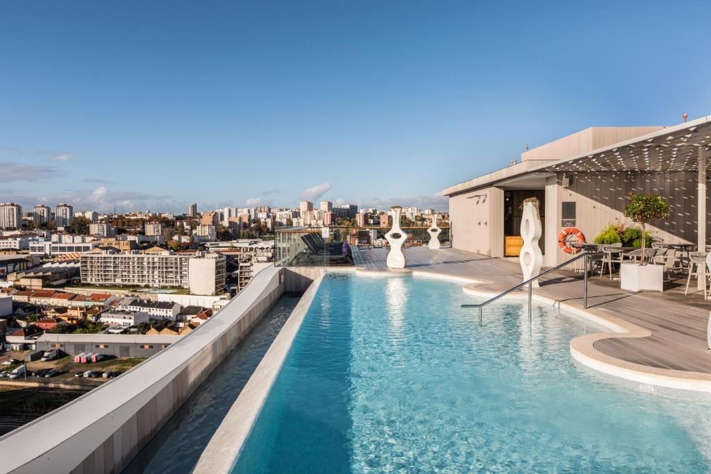 A rooftop pool with city views, sun loungers, and a covered terrace.