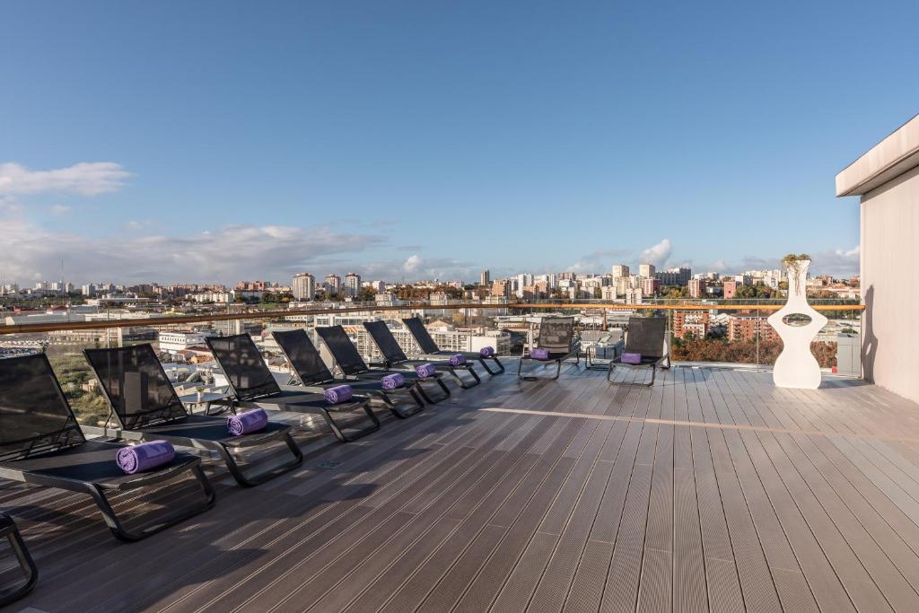 A rooftop sun deck lined with loungers and overlooking the city.