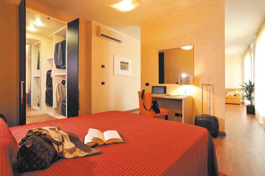 Un dormitorio con una cama roja con un libro. en Hotel Residence Zodiaco, en Módena