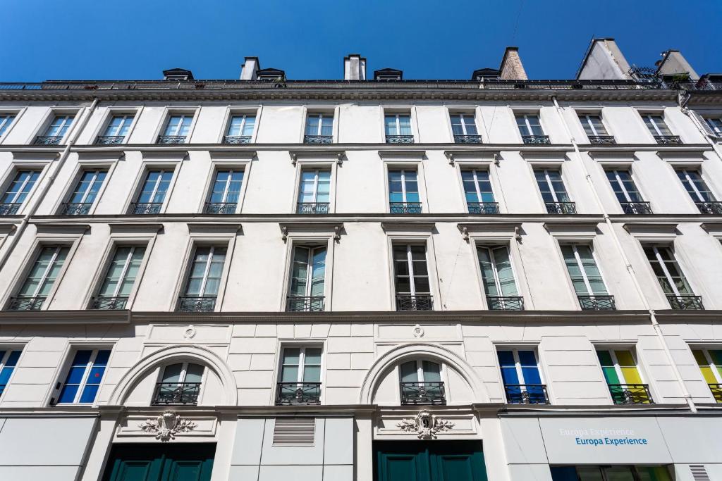 Un grand bâtiment blanc avec de nombreuses fenêtres dans l'établissement Marcel s Madeleine, à Paris