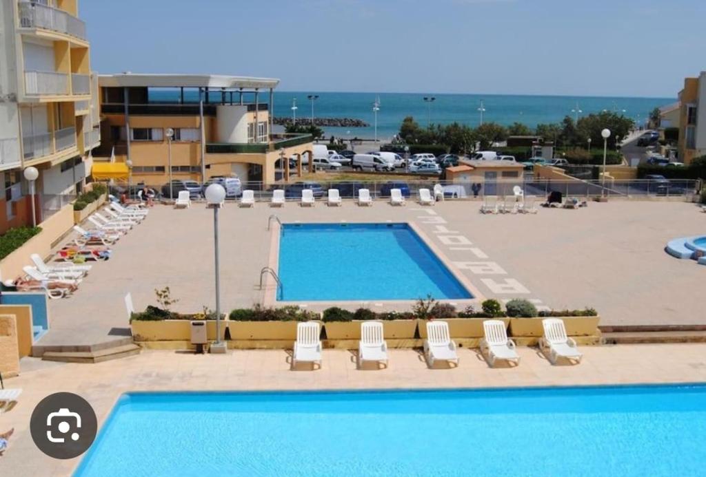 - une vue sur la piscine d'un complexe avec piscine dans l'établissement Appartement climatisé Le cap d'Agde, au Cap d'Agde