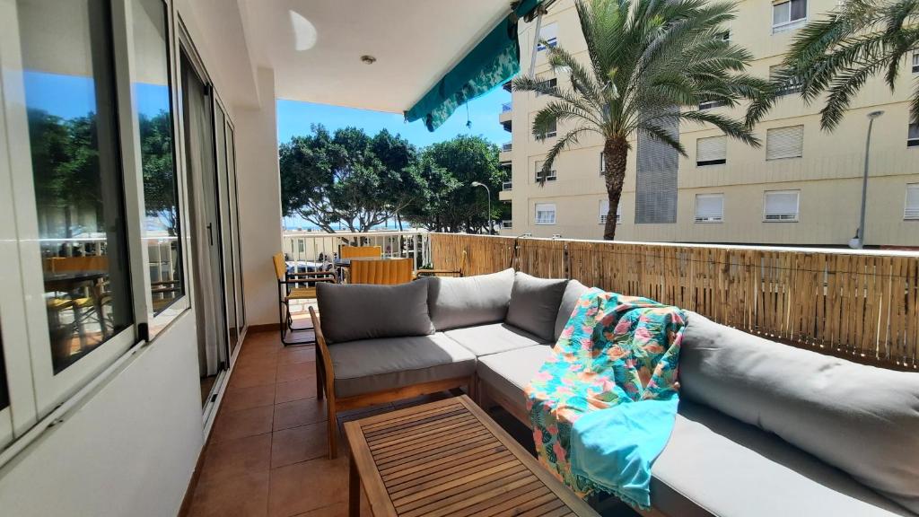 a couch on the balcony of a apartment at Terraza con vistas al mar Parking privado 120 mts, junto a la playa in Cullera