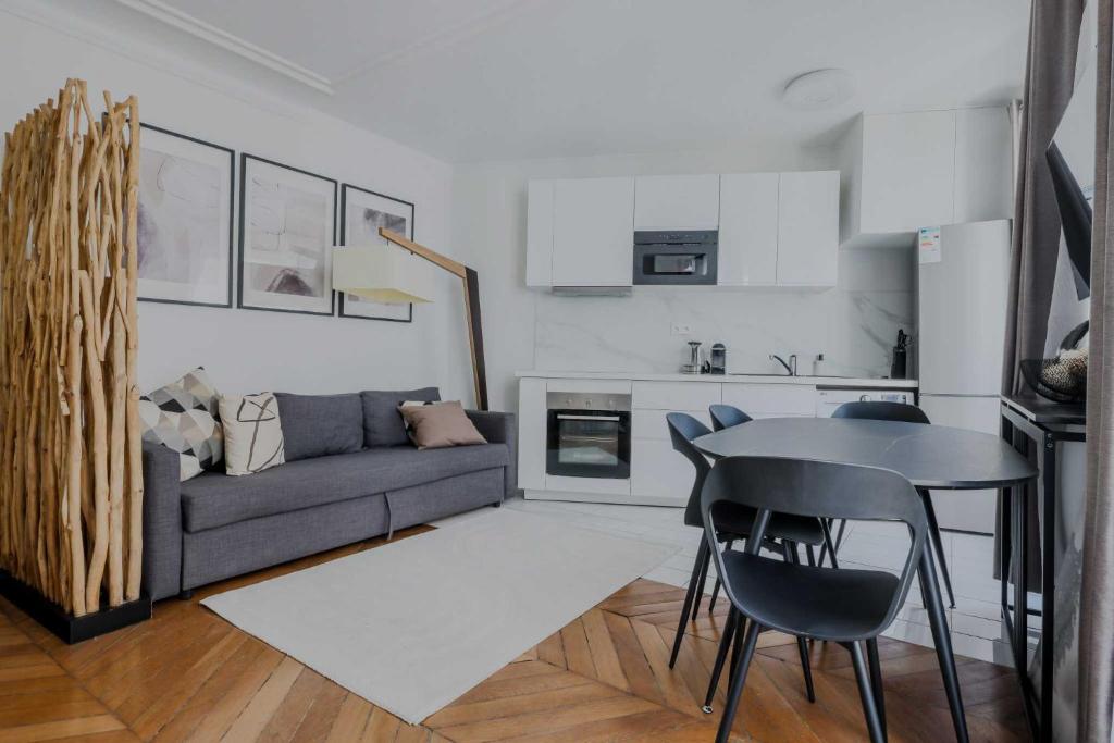 un salon avec un canapé et une table dans l'établissement Charming apartment - 1BD-4P - Gare du Nord, à Paris
