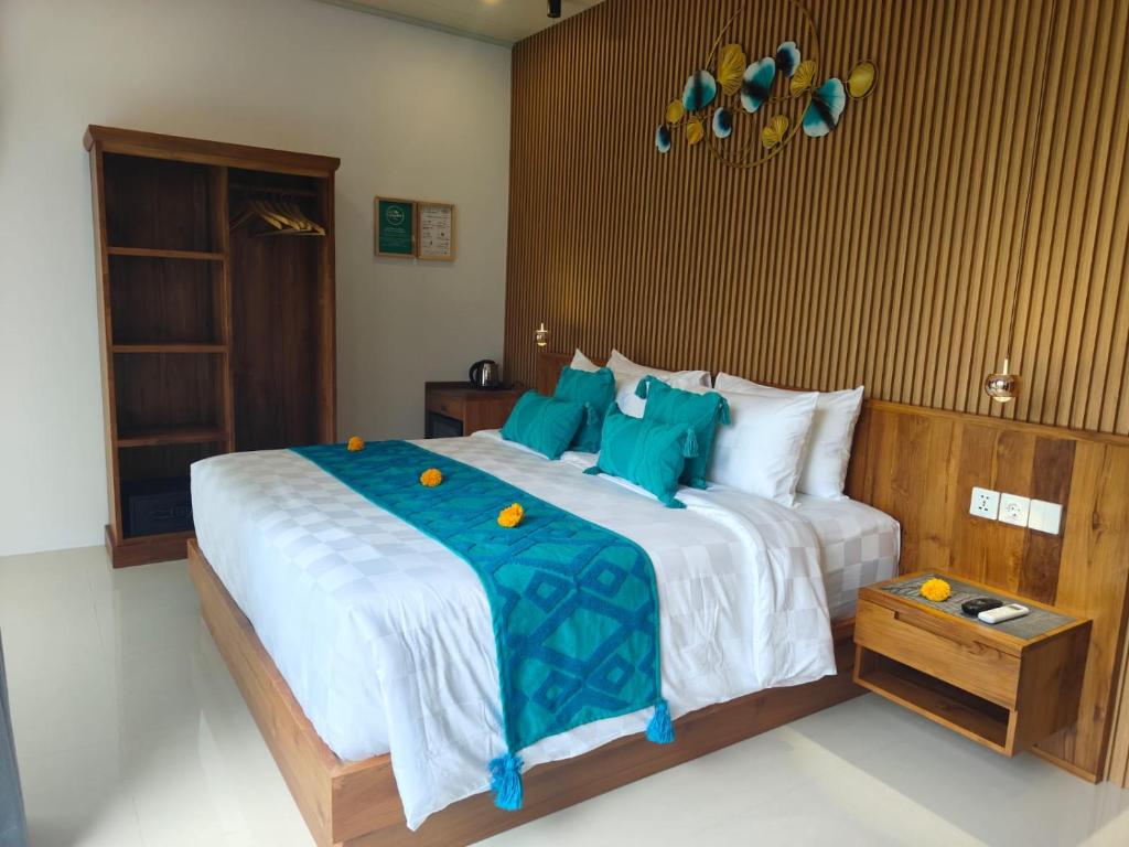 a bedroom with a large bed with blue pillows at The Palms Canggu in Canggu