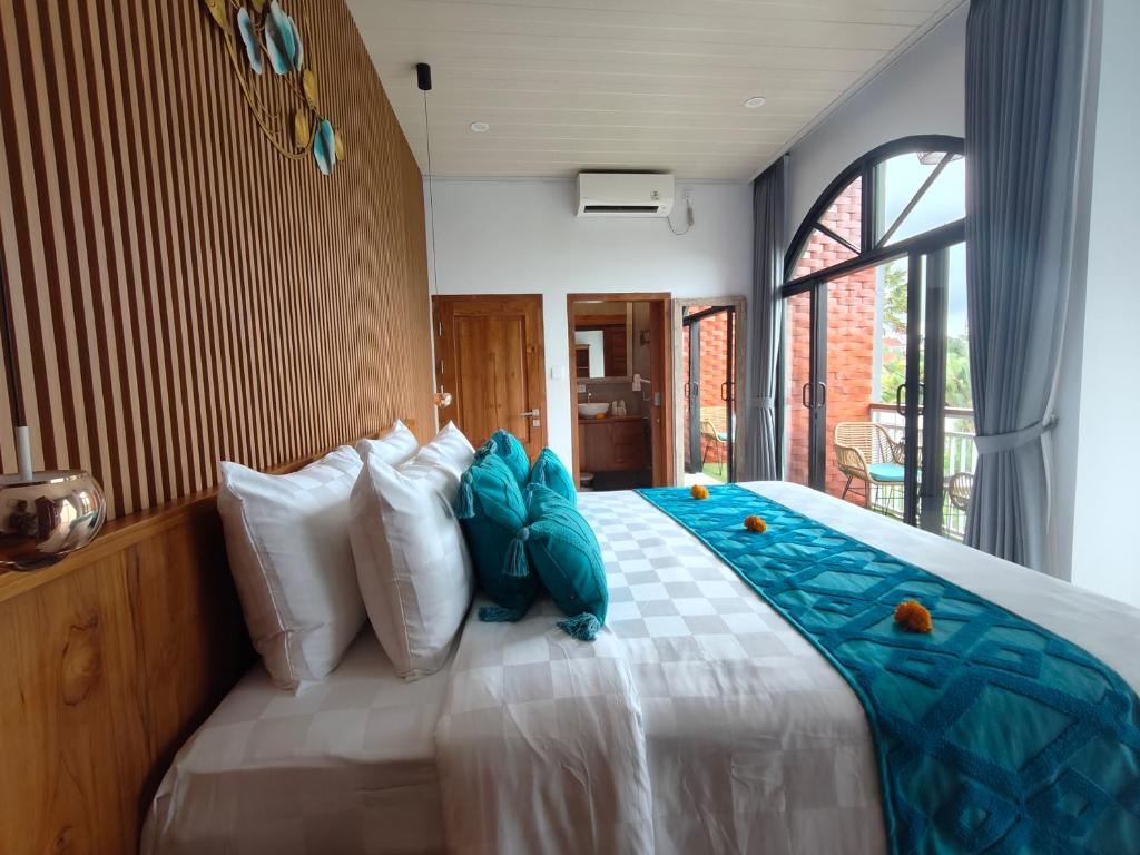 a bedroom with a large bed with blue pillows at The Palms Canggu in Canggu