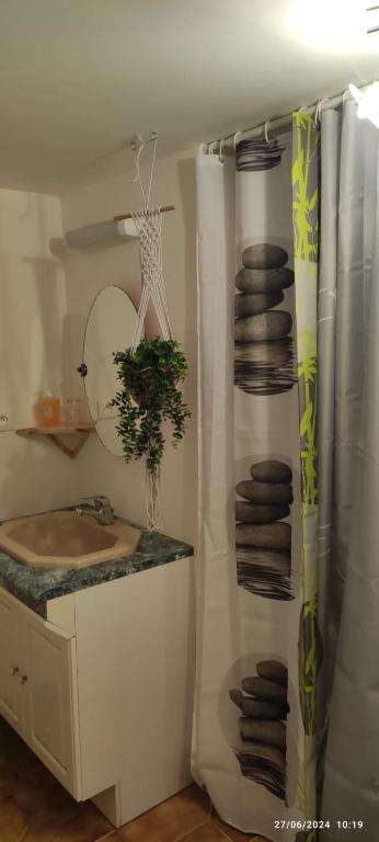 une salle de bain avec un lavabo et un tas de serviettes dans l'établissement A l ombre du figuier, à Cagnac-les-Mines