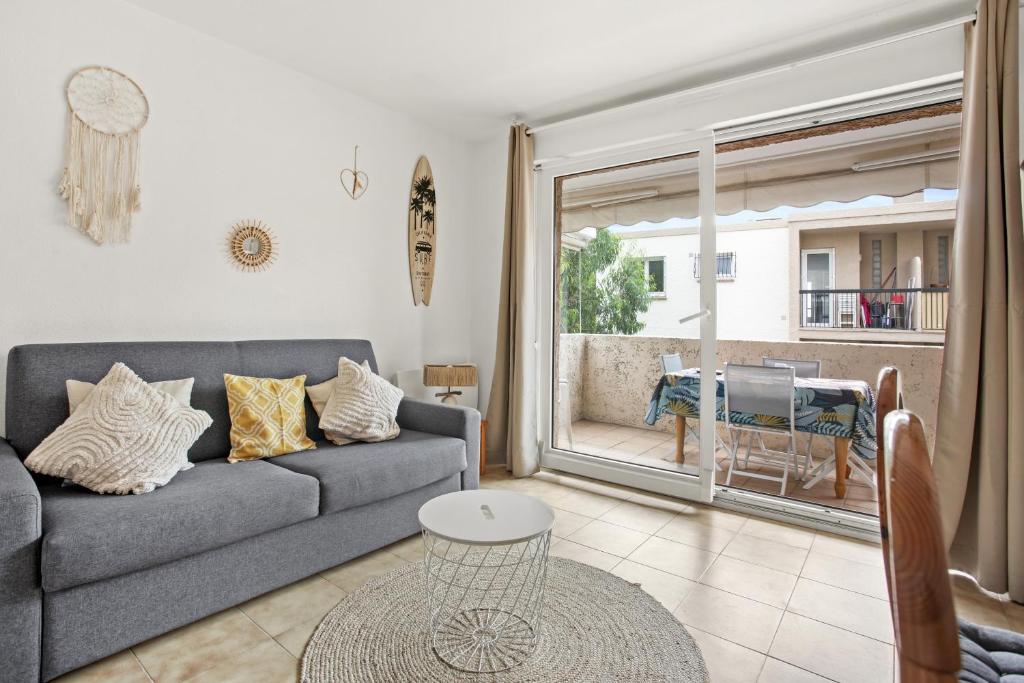 un salon avec un canapé et une grande fenêtre dans l'établissement Studio le Castello 150m de la plage, à Fréjus