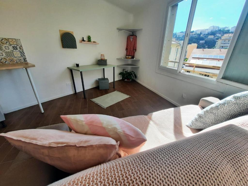 un salon avec un canapé et une grande fenêtre dans l'établissement La Chambre 3, Climatisée AC, Cuisine privée, Calme, à Nice