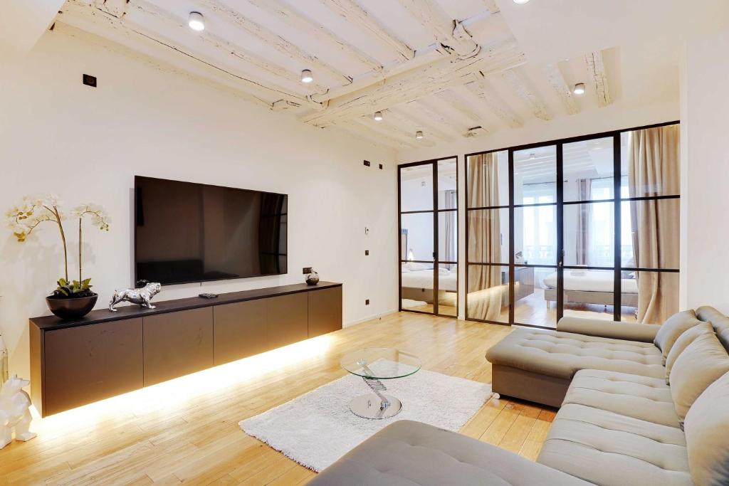 un salon avec un canapé et une télévision dans l'établissement Bright & cosy apartment Palais Royal, à Paris