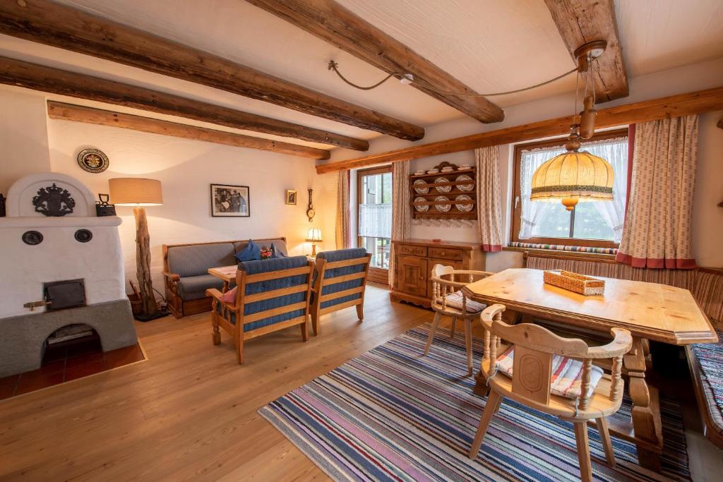 a living room with a table and chairs and a fireplace at Haus Steinbock Top 1 in Krimml
