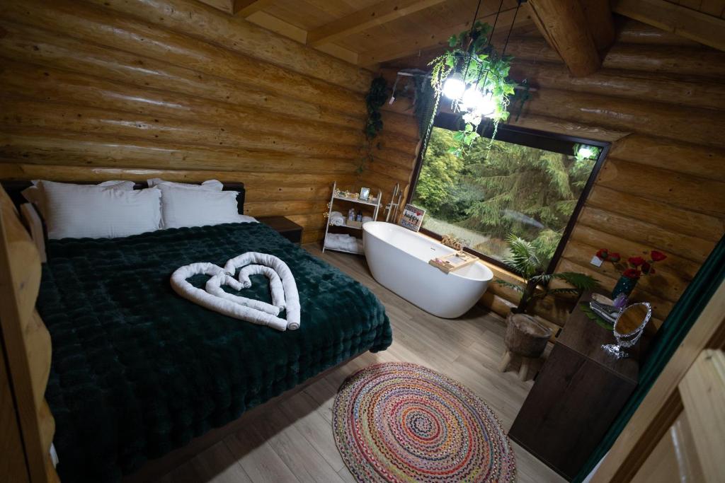 a bedroom with a bed and a bath tub and a window at Casa Bucuriei - Plaiul Foii, Zărnești in Zărneşti