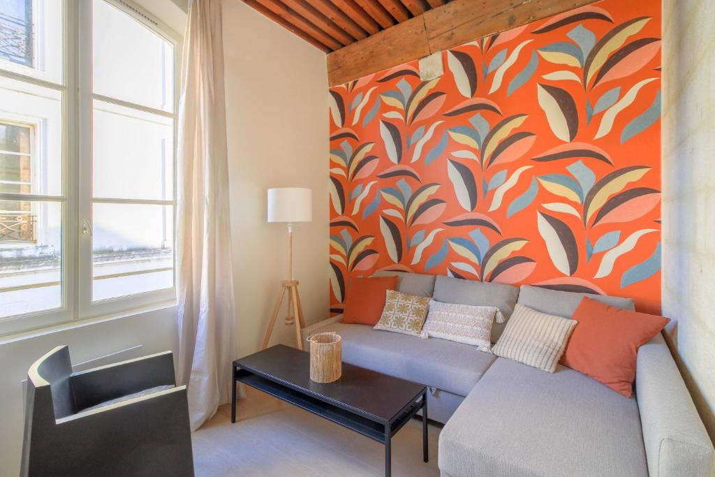- un salon avec un canapé et un mur coloré dans l'établissement Coeur de ville, T2 lumineux et refait à neuf, à Arles