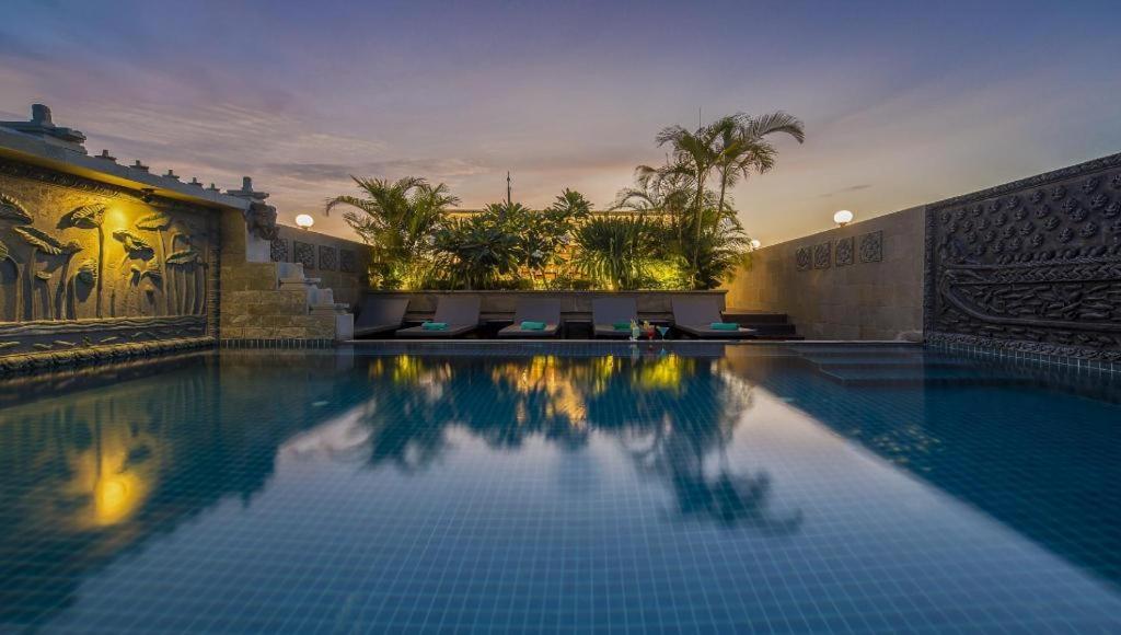 暹粒The Grand Cyclo Boutique Suite & Spa的一栋建筑里亮着灯的大型游泳池