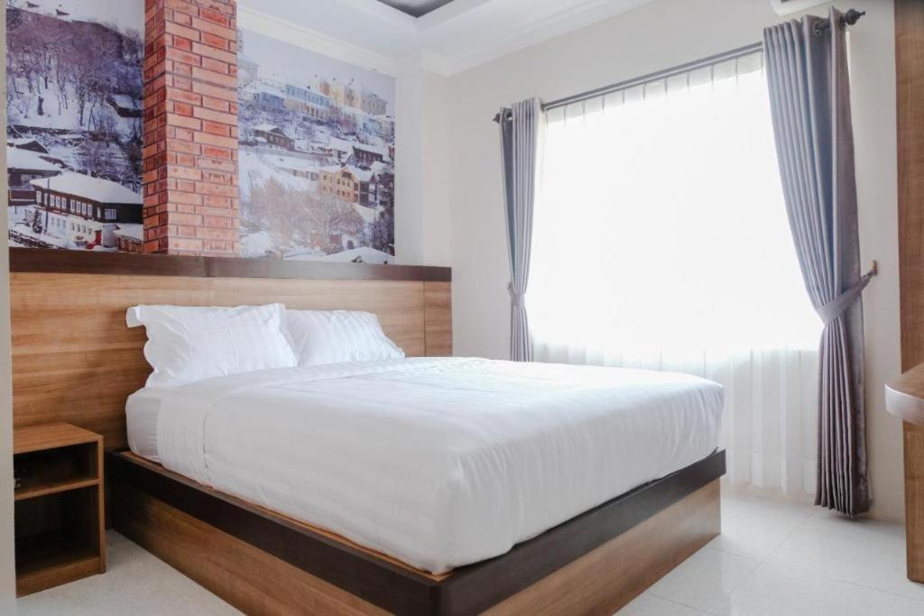 a bedroom with a large bed and a window at Noura Guest House Syariah in Malang