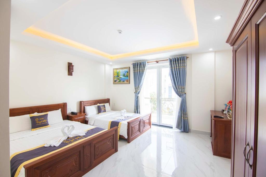 Un dormitorio con dos camas y una ventana. en SinE Hotel VT by BAY LUXURY, en Vung Tau