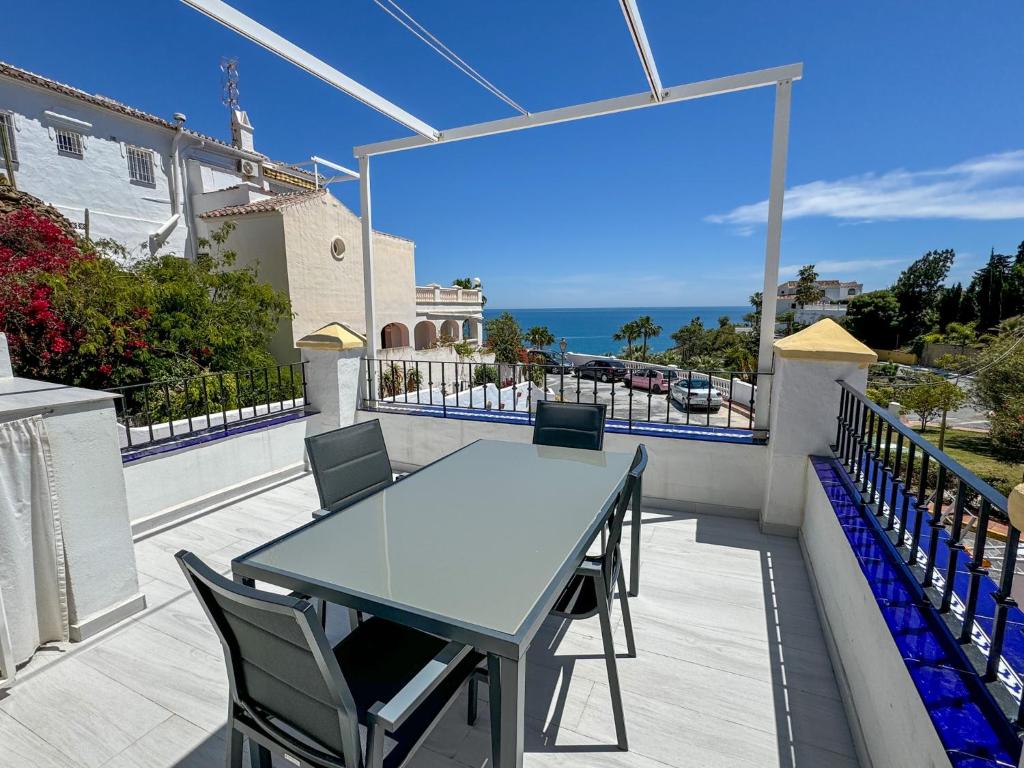 a table and chairs on a balcony with a view of the ocean at Casa Blanca in Torrox Costa